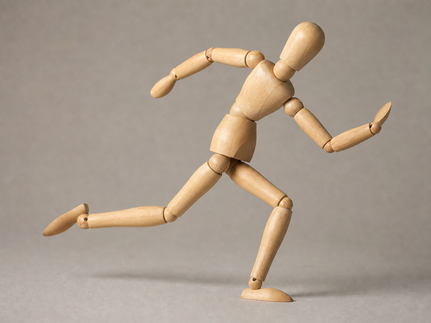 Wooden artist mannequin posed in a dynamic running gesture